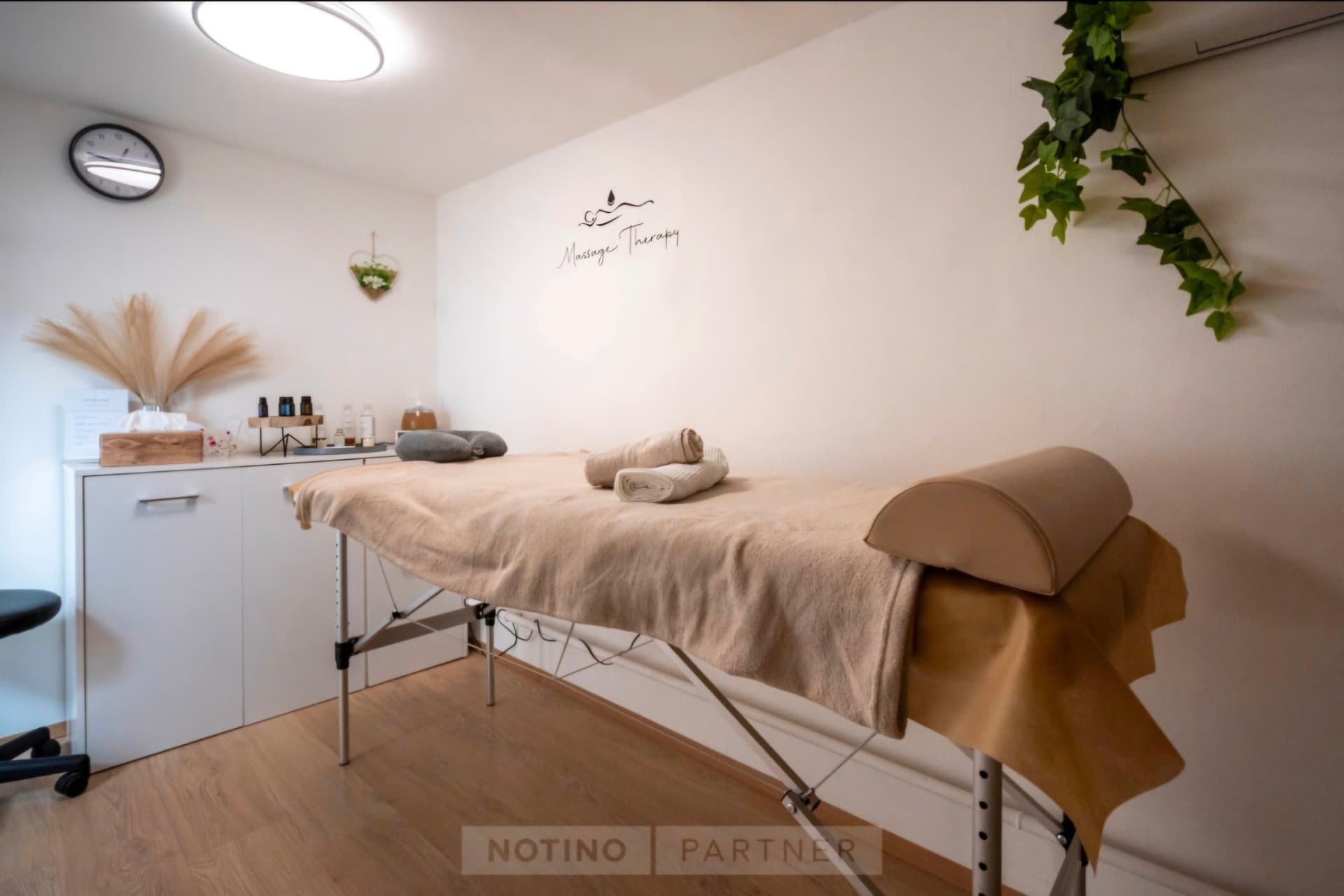 Masszázságy a Massage Therapy feliratos fal előtt
